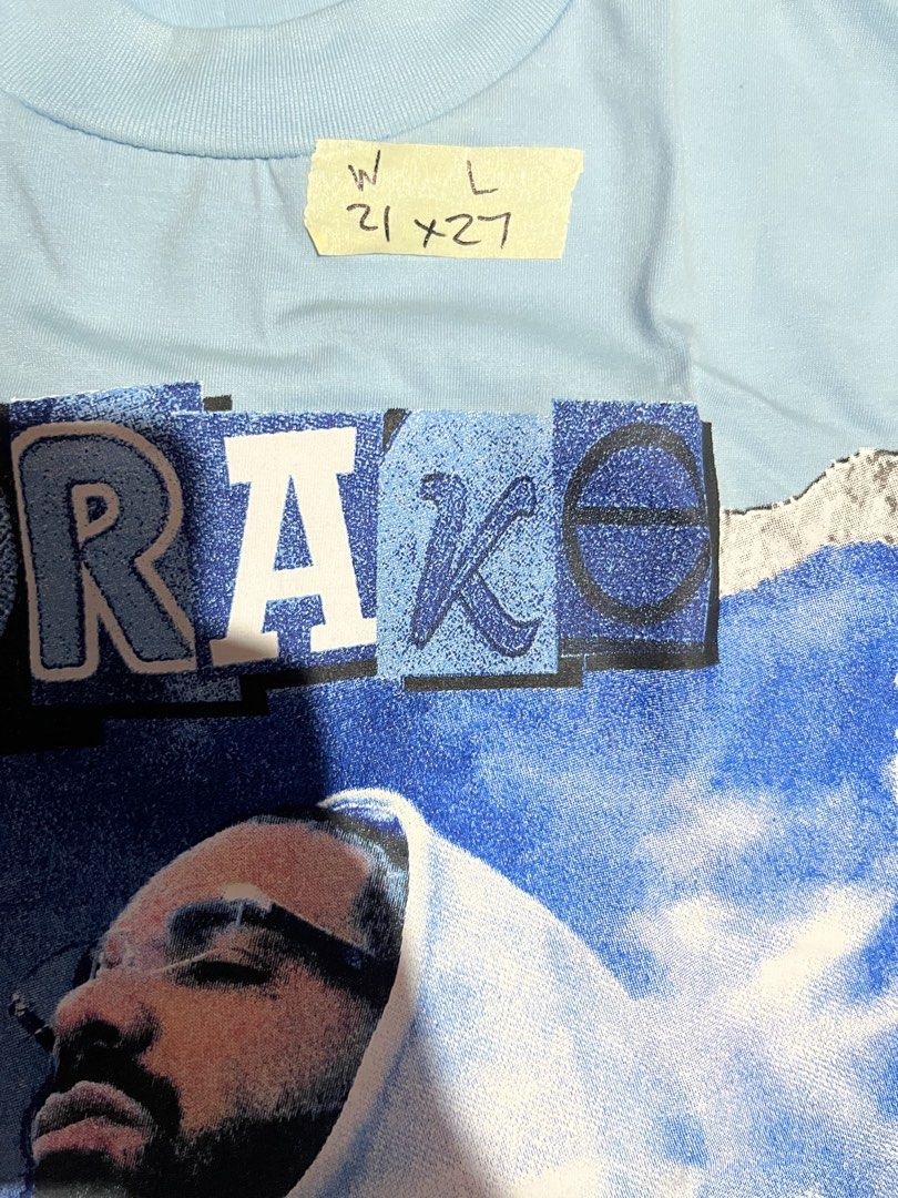 Drake Graphic Tee Light Blue (Category: Tshirts & Polo Shirts ) located in Cavite. Submitted by christianzuuu (Listing ID 1469739116, Image 2). Description: - Brand: Snug Co. - Color: Light blue - Design: Drake CLB graphic on front, 'Jungle' lyrics and song info on back - Material: Heavy cotton - Fit: Relaxed fit - Measurements: 21 inches (width) x 27 inches (length) - Condition: Clean, no stains or flaws.