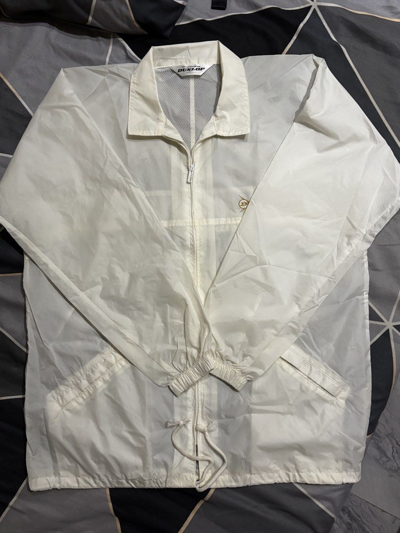 Dunlop Windbreaker Jacket (Category: Coats, Jackets and Outerwear) located in Manila. Submitted by bizcuits (Listing ID 1469739511, Image 1). Description: - Brand: Dunlop - Color: Off White - Size: Large (L) 23 width by 30 length - Design: Full front zip with fold-down collar and small gold embroidered chest logo - Features: Front pockets, drawstring hem, and breathable mesh lining - Condition: Great lightweight outer layer, ideal for breezy days