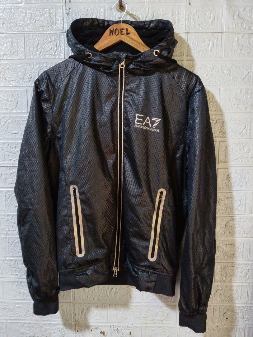 EA7 Emporio Armani Black Hooded Jacket (Category: Coats, Jackets and Outerwear) located in Davao. Submitted by noelamihan05424 (Listing ID 1469621995, Image 3). Description: - Brand: EA7 Emporio Armani - Color: Black with stylish textured pattern throughout - Closure: Full zip with sleek silver accents - Pockets: Convenient zippered side pockets - Safety/Style: Reflective strip detail on the back - Fit: Ribbed cuffs and hem to block out the wind 