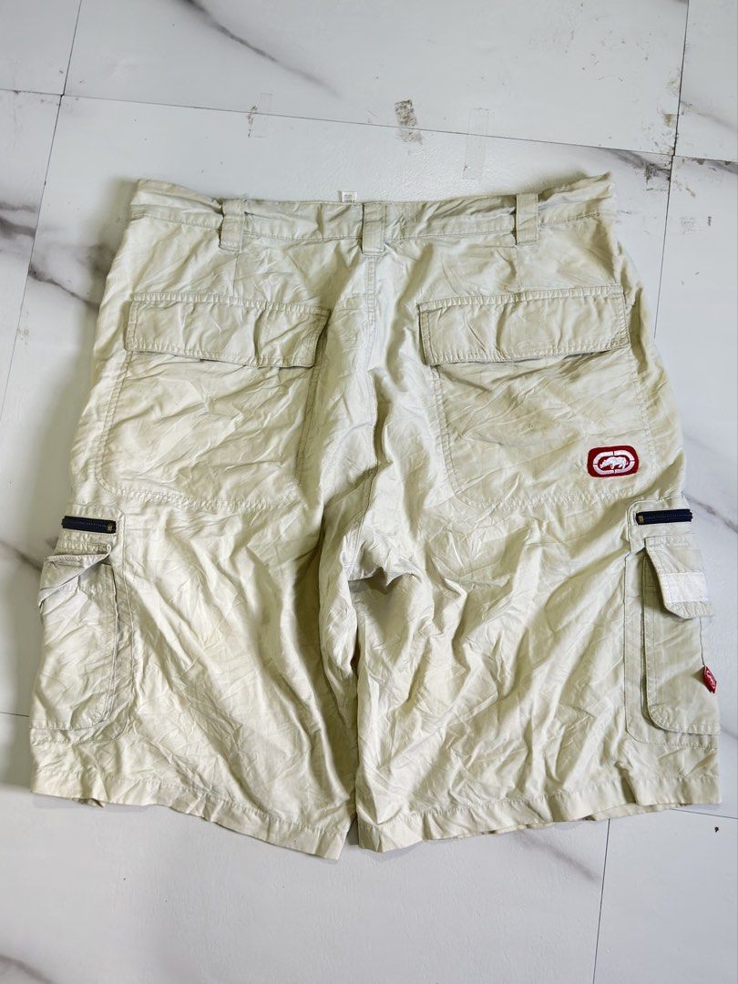 Ecko Unltd Beige Cargo Shorts with Zipper Pockets (Category: Shorts) located in Cavite. Submitted by remcadzzz (Listing ID 1469609694, Image 2). Description: - Brand: Ecko Unltd - Color: Classic beige - Material: Sturdy, durable cotton fabric - Pockets: Multiple utility pockets with secure zipper closures and red logo tag - Details: Signature rhino embroidery on the back pocket, waistband with belt loops - Style: Streetwear staple, versatile and 