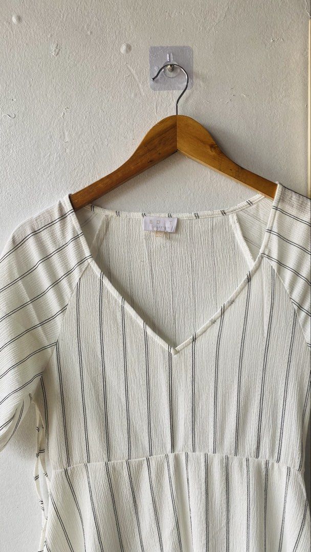 Edit Collection White Black Stripe V-Neck Dress (Category: Dresses) located in Caloocan City. Submitted by lovemyclothes21 (Listing ID 1469615892, Image 3). Description: - Style: White midi dress with vertical black stripes - Details: V-neckline, short puff sleeves with tie cuffs, fitted bodice, and flared skirt - Fabric: Lightweight, textured material - Size: Medium (tag attached) - Condition: Brand new / Excellent - Best for: Casual outings and