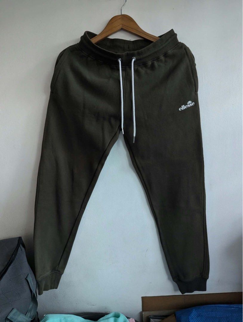 Ellesse Olive Green Sweatpants UK S (Category: Joggers) located in Quezon City. Submitted by thegoodkarmaph (Listing ID 1469681342, Image 1). Description: - Brand: Ellesse - Size: UK Small - Color: Dark olive green - Material: Soft fleece interior lining (Made in China) - Waistband: Thick ribbed with long white drawstrings and silver metal tips - Details: Small white brand logo on left thigh - Cuffs: Elasticated at the ankles.
