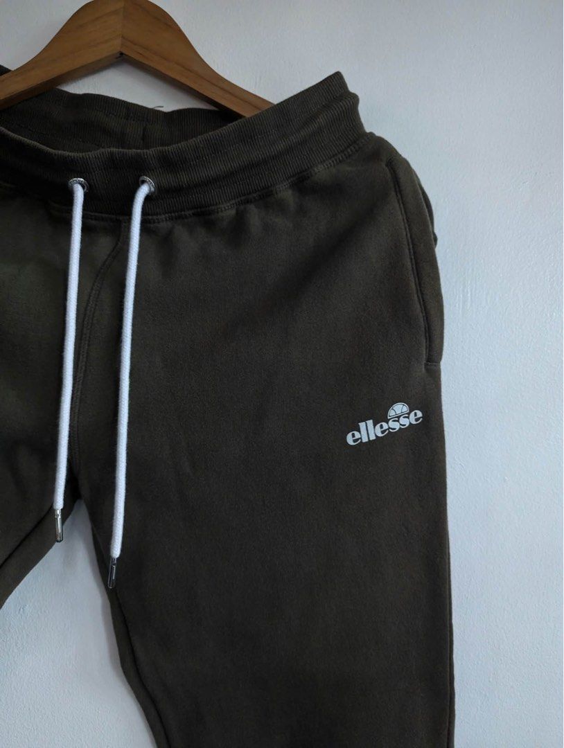 Ellesse Olive Green Sweatpants UK S (Category: Joggers) located in Quezon City. Submitted by thegoodkarmaph (Listing ID 1469681342, Image 2). Description: - Brand: Ellesse - Size: UK Small - Color: Dark olive green - Material: Soft fleece interior lining (Made in China) - Waistband: Thick ribbed with long white drawstrings and silver metal tips - Details: Small white brand logo on left thigh - Cuffs: Elasticated at the ankles.