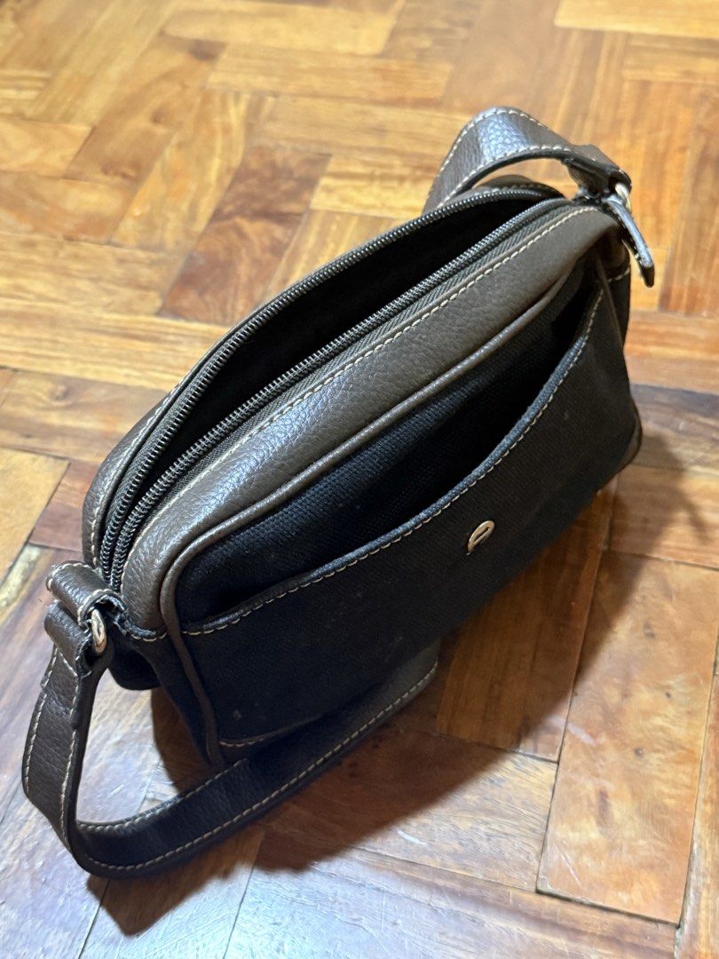 Etienne Aigner Black Canvas Leather Shoulder Bag (Category: Shoulder Bags) located in Manila. Submitted by only_alyssacloset (Listing ID 1469647724, Image 2). Description: Brand: Etienne Aigner Material: Durable black canvas with dark brown leather trim Hardware: Silver-tone with classic horseshoe logo on front pocket .