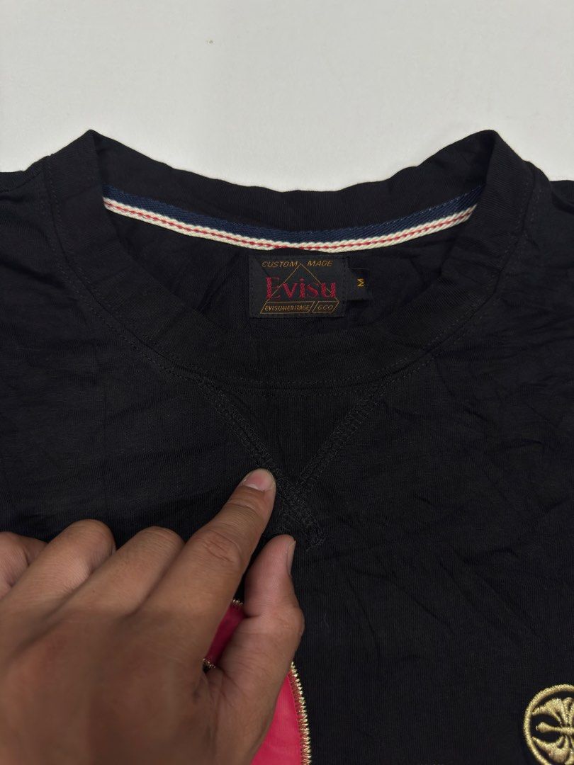 Evisu Heritage Black T-shirt Size M (Category: Tshirts & Polo Shirts ) located in Bustos. Submitted by thenlnclot60500 (Listing ID 1469582132, Image 3). Description: - Brand: Evisu Heritage - Color: Black - Size: Men's Medium (M) - Design: Large pink and gold embroidered seagull logo with "Before anyone did anything evisu did everything" slogan - Details: Small circular gold embroidery, woven brand labels at hem and back neckline - Interior: Stri
