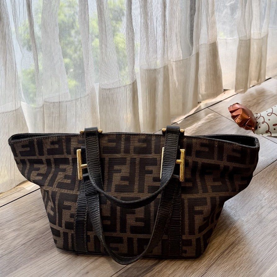 Fendi Mini Triangle Tote Bag (With Entrupy COA) (Category: Tote Bags) located in Marikina City. Submitted by reloved8 (Listing ID 1469738000, Image 1). Description: ✨ VINTAGE FENDI MINI TRIANGLE TOTE BAG IN TOBACCO ZUCCA CANVAS ✨ Selling my authentic, highly collectible vintage Fendi Mini Triangle Boat Tote Bag. This features the iconic interlocking FF monogram jacquard canvas with dark brown genuine leather handles and trim. Unlike the common fl