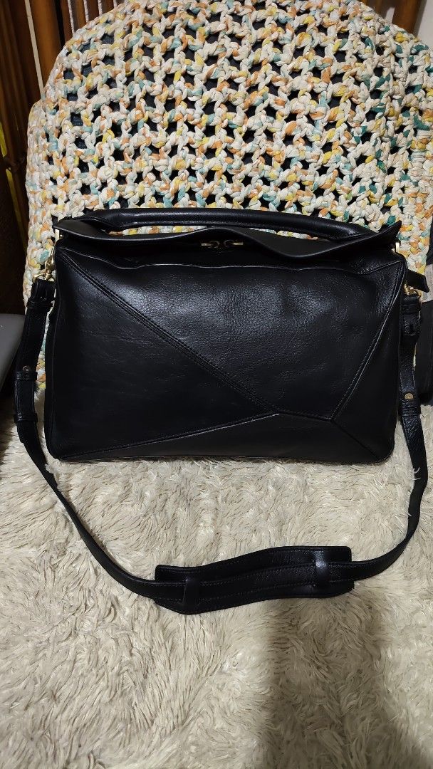 Finn esker (Category: Cross-body Bags) located in Cebu City. Submitted by lumaynojes00490 (Listing ID 1469670311, Image 2). Description: - Material: Premium black leather with soft feel - Design: Iconic geometric paneling with structured shape - Hardware: Gold-tone zippers and clasps - Versatility: Includes a rolled top handle and adjustable shoulder strap - Usage: Perfect daily-sized shoulder bag that matches any outfit.