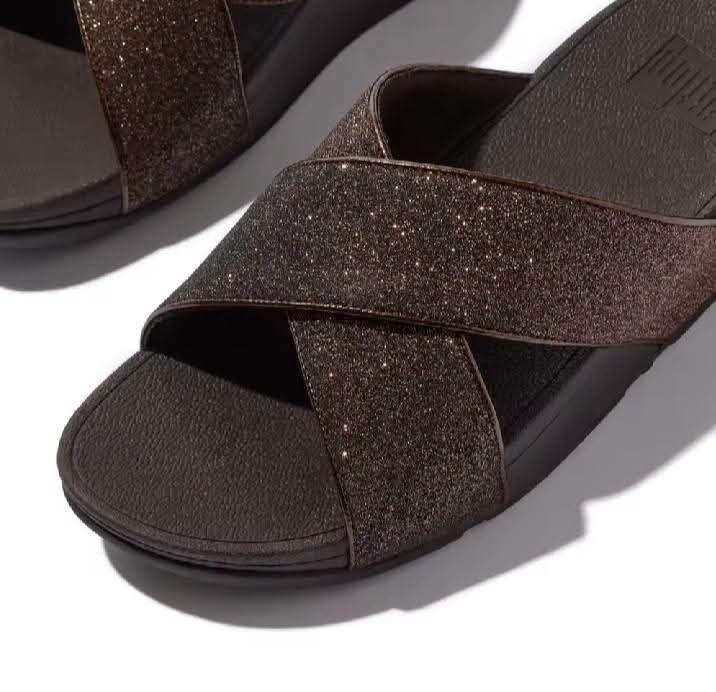 FitFlop Glitter Cross-Strap Slide Sandals Brown (Category: Flats & Sandals) located in Las Pinas. Submitted by dalogdogjh77505 (Listing ID 1469604153, Image 1). Description: - Color: Brown - Design: Sparkly cross-straps with a subtle shimmer - Comfort: Textured footbed for all-day support - Heel: Chunky wedge design - Style: Easy slip-on - Best for: Everyday walking or running errands.