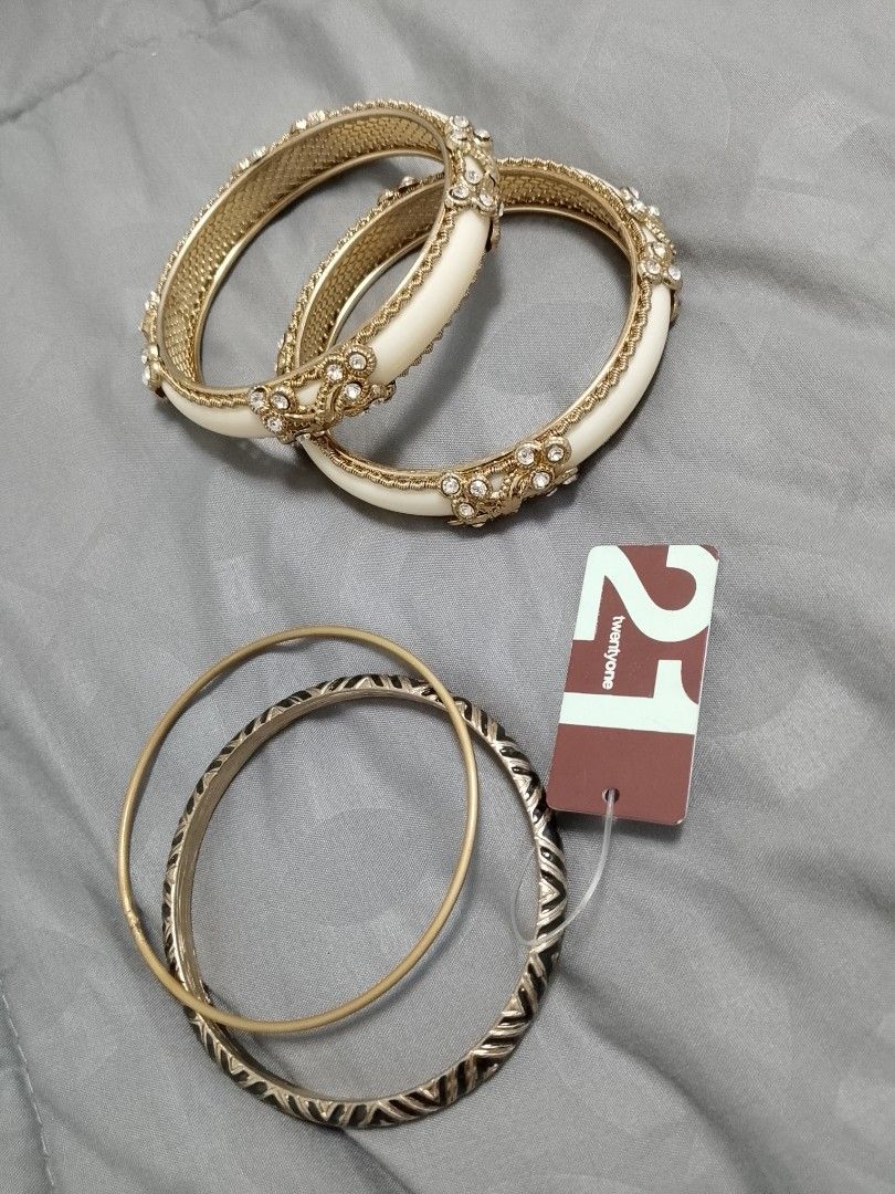 Forever 21 Bracelet Bangle Set (Category: Bracelets) located in Manila. Submitted by batchi1019 (Listing ID 1469582688, Image 1). Description: - Brand: Forever 21 - Condition: Brand new with tags attached - Quantity: Set of 5 bangles - Includes: 2 chunky off-white and gold rhinestone flower bracelets, 1 thin matte gold wire bangle, and 2 textured black and gold patterned bangles - Styling: Wear stacked together or mix and match.
