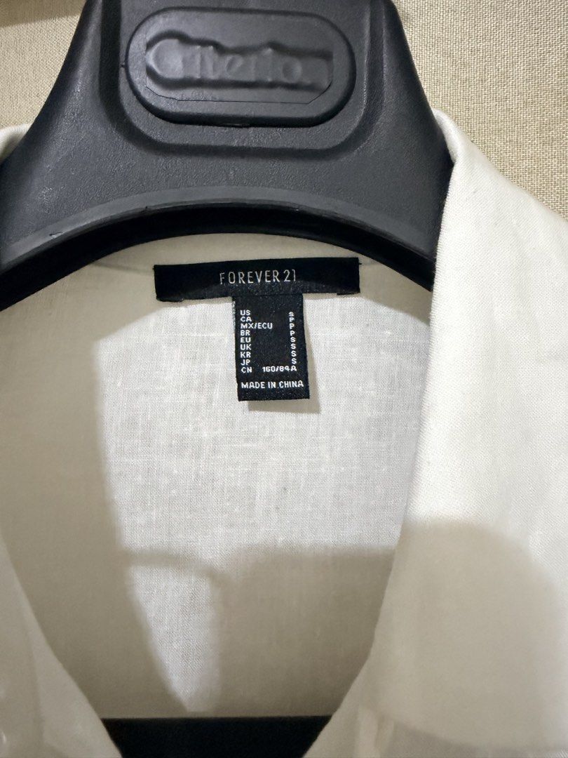 Forever 21 White Button-Down Shirt Size S (Category: Shirts) located in Cavite. Submitted by mgd.blessed (Listing ID 1469632642, Image 2). Description: - Brand: Forever 21 - Size: S (Oversized fit) - Color: White - Details: Classic collar, front chest pocket, button-up front, long sleeves - Fabric: Lightweight with a slight texture - Style: Clean minimalist staple, easy to layer or wear solo - Condition: Excellent.