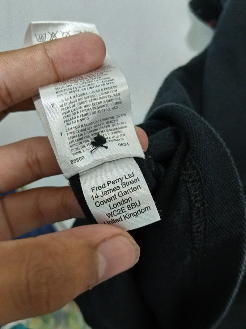 Fred Perry Black Polo Shirt M3344 (Category: Tshirts & Polo Shirts ) located in Abucay. Submitted by ukay_withdj (Listing ID 1469660086, Image 3). Description: Black Fred Perry polo shirt in size XL, percent cotton material made in China. Contrasting red geometric floral pattern inside the collar and sleeve cuffs. Classic embroidered red laurel wreath logo on the left chest. Button placket front with branded spare button attached to the inner car