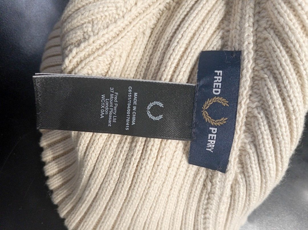 Fred Perry Ribbed Beanie Hat Cream (Category: Beanies) located in Makati City. Submitted by saicohtikz (Listing ID 1469699241, Image 3). Description: - Brand: Fred Perry - Color: Cream - Design: Ribbed knit with front foldover cuff - Logo: Iconic embroidered laurel wreath patch - Details: Inner tag with product code C6151 and London address - Origin: Made in China - Condition: Perfect cozy winter headwear accessory.