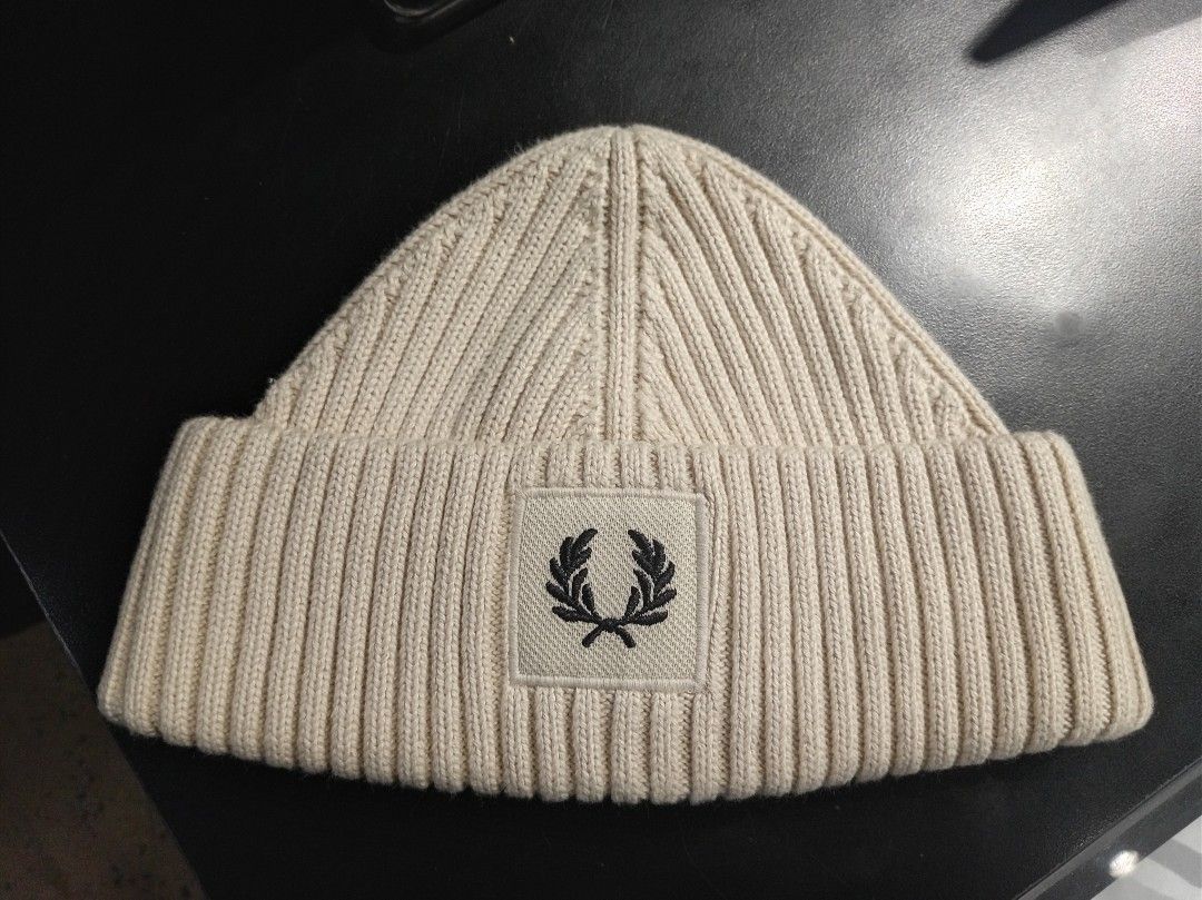 Fred Perry Ribbed Beanie Hat Cream (Category: Beanies) located in Makati City. Submitted by saicohtikz (Listing ID 1469699241, Image 1). Description: - Brand: Fred Perry - Color: Cream - Design: Ribbed knit with front foldover cuff - Logo: Iconic embroidered laurel wreath patch - Details: Inner tag with product code C6151 and London address - Origin: Made in China - Condition: Perfect cozy winter headwear accessory.
