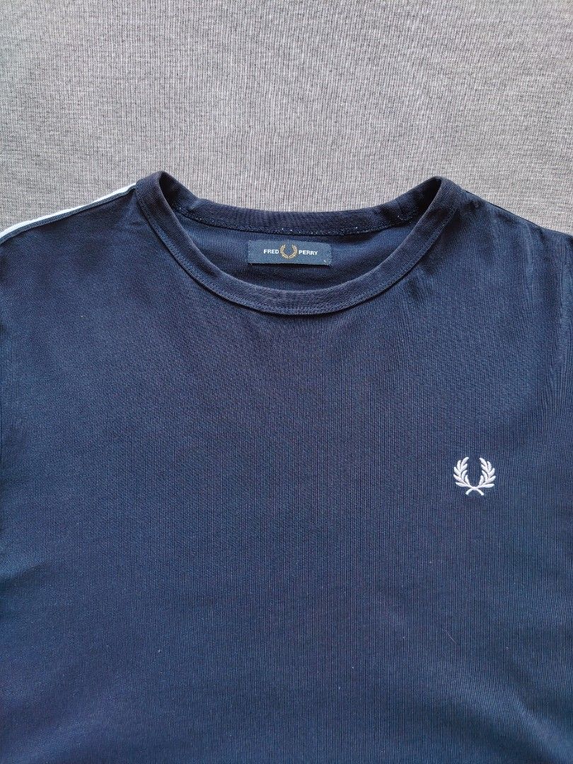 Fred Perry Side Tape LS (Category: Tshirts & Polo Shirts ) located in Taguig. Submitted by _theroom.ph (Listing ID 1469634599, Image 2). Description: - Brand: Fred Perry - Style: Long sleeve t-shirt with crew neck - Color: Dark navy blue - Size: L - Details: White Laurel Wreath taped stripes on sleeves and small embroidered chest logo - Condition: Clean, casual everyday streetwear piece - Origin: Made in China Fred Perry Side Tape LS Size Large 2