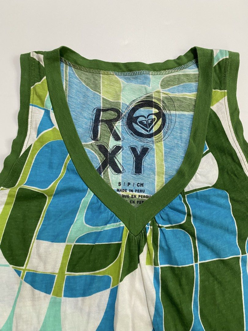Frutiger aero roxy top (Category: Sleeveless) located in Dumangas. Submitted by hakdoooog (Listing ID 1469682223, Image 2). Description: - Brand: Roxy - Size: Small (Made in Peru) - Design: Blue, green, and white geometric pattern with olive green trim - Details: V-neck with gathered front detail - Fabric: Lightweight and breathable knit - Condition: Excellent, perfect for sunny days and easy styling.