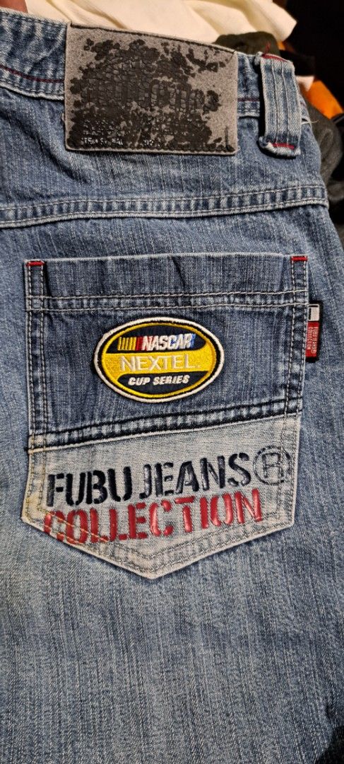FUBU Jeans Ford Mustang Patchwork Denim Pants 32/39 (Category: Jeans) located in San Fernando, Camarines Sur. Submitted by ladderaya (Listing ID 1469642441, Image 3). Description: - Brand: FUBU - Style: Light blue wash denim pants with classic Y2K streetwear vibe - Details: Heavy patchwork, Ford and Mustang branding, NASCAR patch on the back pocket, and logo prints down the legs - Size: Tag reads 32/39 - Condition: Back leather patch is cracked a