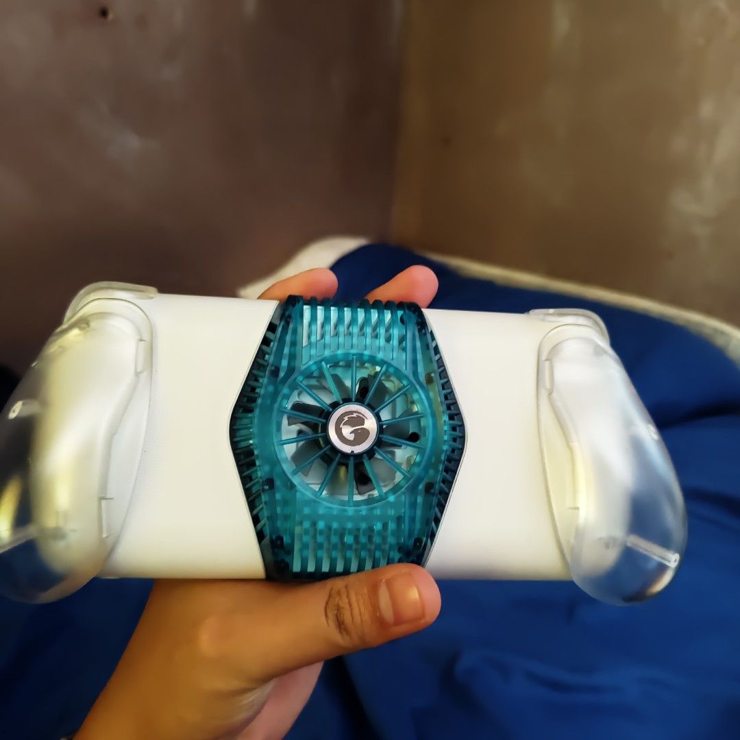 Gamesir Mobile Gaming Controller with Cooling Fan Teal White (Category: Controllers) located in Rizal. Submitted by lclavite6 (Listing ID 1469594506, Image 2). Description: - Color: Teal and white - Condition: Used with minor handling marks - Cooling: Built-in cooling fan to prevent overheating - Compatibility: Adjustable clamp fits most smartphones - Connectivity: Type-C connector plug on the right side - Controls: Standard thumbsticks, D-pad, a