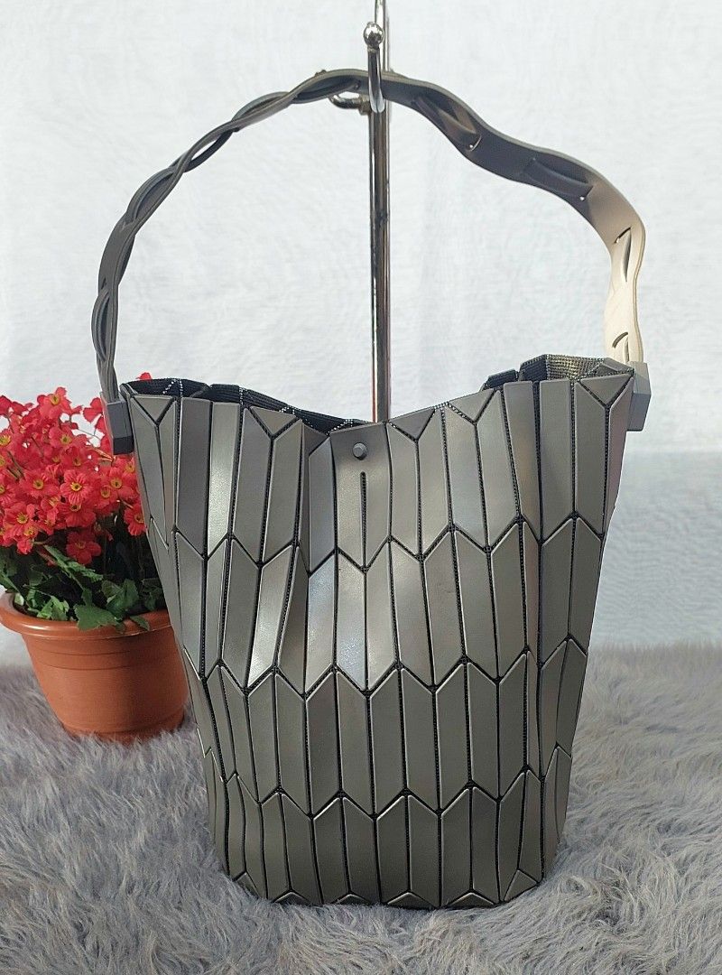Geometric Pattern Bucket Bag Grey (Category: Luxury Bags & Wallets) located in Quezon City. Submitted by ruthie3 (Listing ID 1469632581, Image 1). Description: - Colour: Neutral metallic grey - Design: Unique geometric interlocking tile pattern - Structure: Sturdy and stands upright on its own - Strap: Dark braided strap attached at the sides - Interior: Fabric-lined opening - Style: Versatile and perfect for daily outfits.
