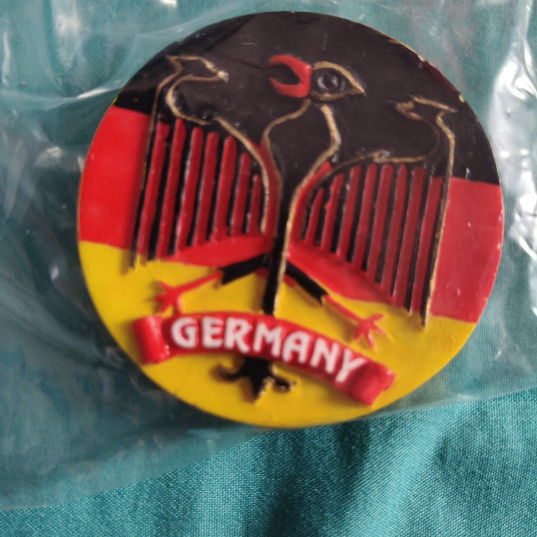 Germany Badge Pin with Eagle Design (Category: Brooches) located in Las Pinas. Submitted by chaerful8 (Listing ID 1469580292, Image 2). Description: - Round German novelty badge - Features national eagle emblem with red, black, and yellow color blocking - "GERMANY" stamped clearly on a red banner - Brand new and still sealed in clear protective plastic - Great collectible piece and souvenir for pin enthusiasts.