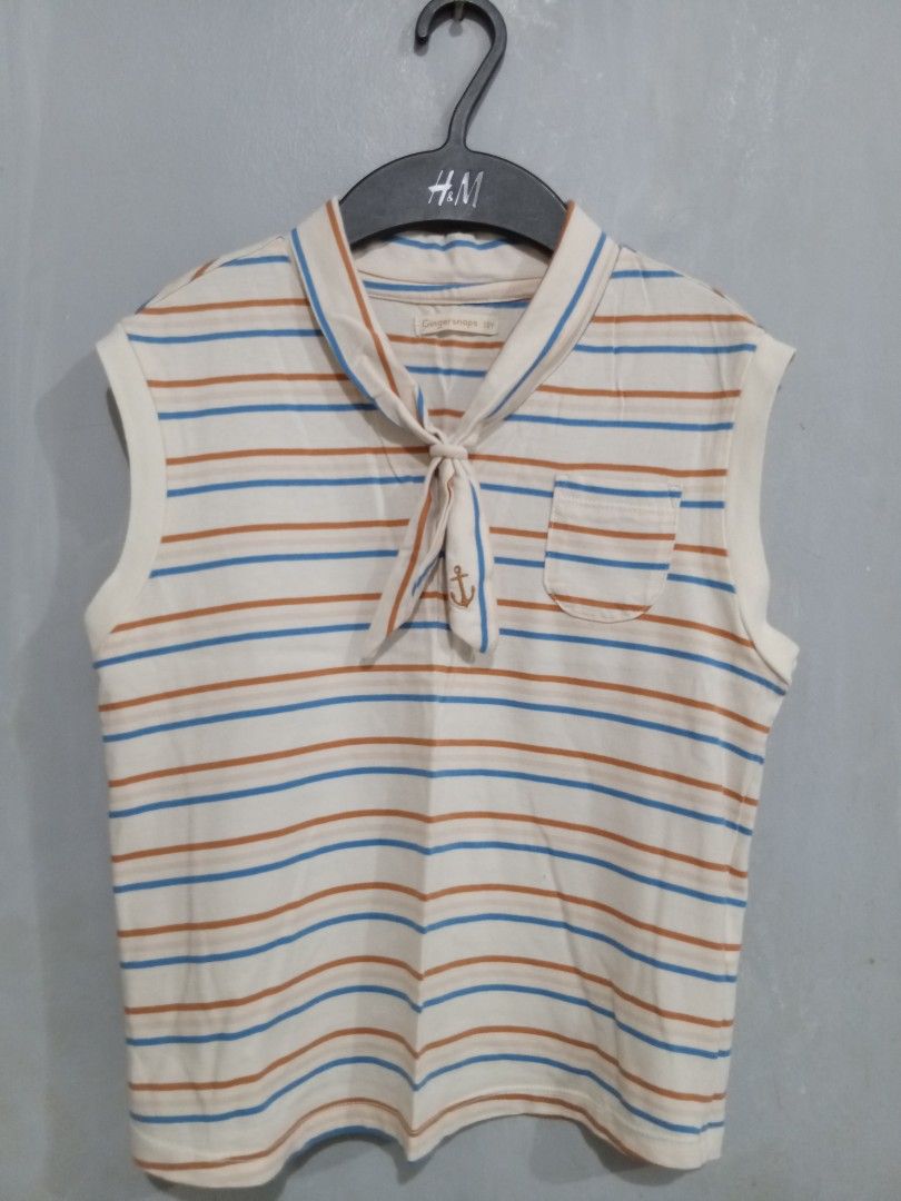 Gingersnaps Sleeveless Striped Sailor Collar Top (Category: Babies & Kids Fashion) located in Bacoor. Submitted by thriftworksph (Listing ID 1469611440, Image 1). Description: - Brand: Gingersnaps - Size: 12Y - Design: Cream with brown and blue horizontal stripes - Details: Sailor style collar with front tie, anchor embroidered chest pocket - Material: Lightweight cotton, ideal for warm weather - Condition: Clean and well-maintained.