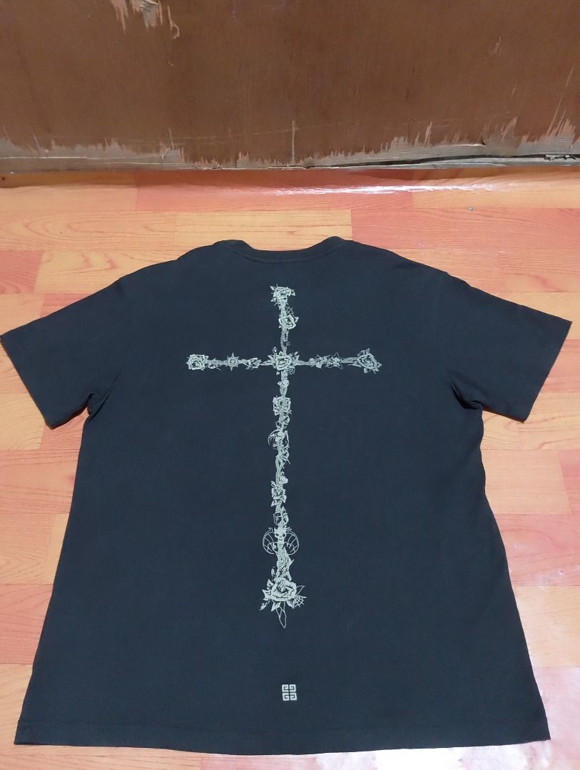 Givenchy Black T-Shirt with Cross Back Print (Category: Tshirts & Polo Shirts ) located in Cavite. Submitted by marvzclothing (Listing ID 1469696480, Image 2). Description: - Brand: Givenchy - Color: Black - Size: Medium on tag ( Fit to large ) - Material: 100% cotton with viscose ribbing (Made in Portugal) - Front Details: Small star and graphic emblem near the neckline - Back Details: Large, detailed cross graphic with a small logo at the botto