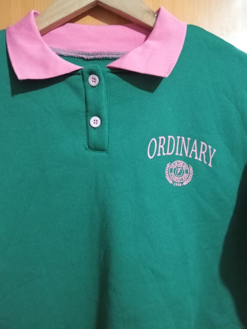 Green pink Ordinary polo sweatshirt (Category: Longsleeves) located in Quezon City. Submitted by niceoutfits (Listing ID 1469715657, Image 3). Description: - Color: Green with pink accents - Age : 10 yr old - Design: Pink polo collar, sleeve stripes, chest text, and circular crest graphic - Closure: Two-button placket at the neckline - Details: Ribbed cuffs and hem for a snug fit - Interior: Soft, warm fleece fabric inside - Condition: Brand new 