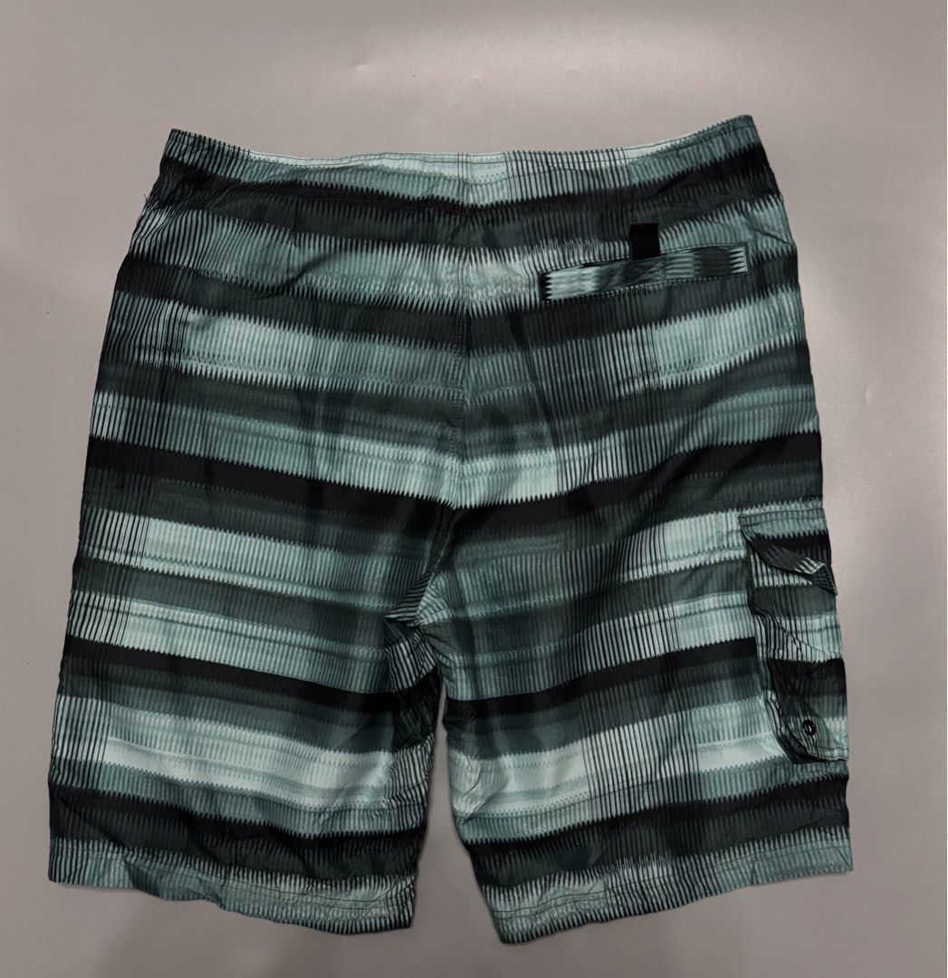 Green Striped Board Shorts Size 34 (Category: Swim Trunks & Board Shorts) located in Alaminos. Submitted by outfitcheck.ph (Listing ID 1469699076, Image 2). Description: - Size: 34 - Color: Green and black stripes - Material: 100% quick-dry polyester - Waistband: Adjustable drawstring with black cords - Pockets: Convenient side cargo pocket and small back pocket with velcro closure - Versatile: Great for swimming, the beach, or casual everyday we
