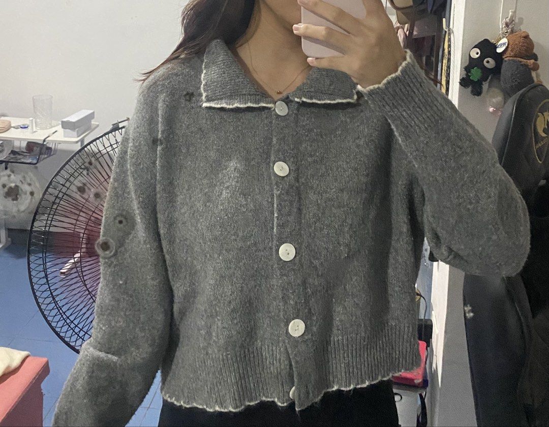Grey knitted button-up cardigan with collar (Category: Coats, Jackets and Outerwear) located in Bulacan. Submitted by nonu_sells (Listing ID 1469686708, Image 2). Description: - Colour: Grey with white trim - Style: Long sleeves, front buttons, lapel collar - Fit: Relaxed, slightly cropped - Material: Soft and comfortable knit - Versatility: Easy to layer over basic tops and matches most bottoms.