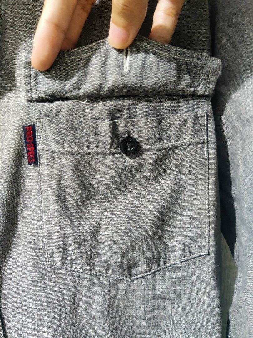 Grey Long Sleeve Shirt (Category: Tshirts & Polo Shirts ) located in Pasig City. Submitted by shiyenaaa (Listing ID 1469672007, Image 3). Description: - Brand: Pro Specs - Style: Long sleeve button-down shirt with classic collar - Color: Grey - Size: 45 - Details: Two chest pockets, one with a small red brand tab, and dark front buttons - Condition: Great casual piece for everyday wear.