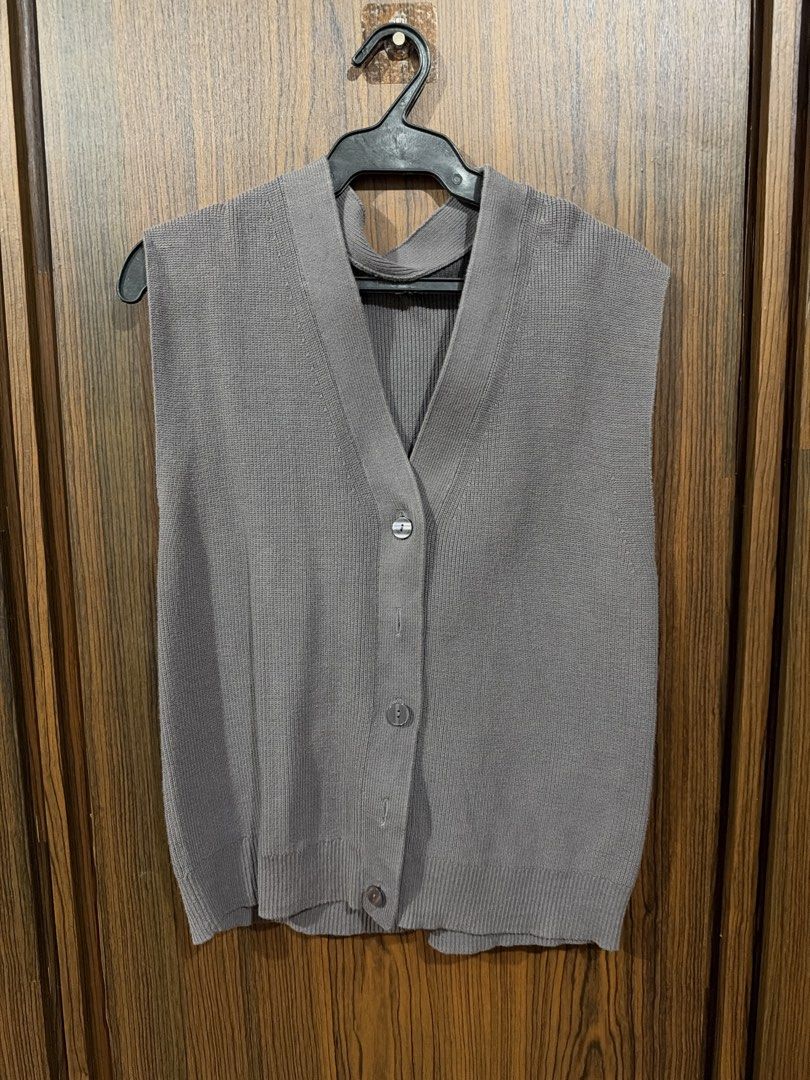 Grey V-Neck Knit Button-Up Sweater Vest (Category: Sleeveless) located in Quezon City. Submitted by co.coph (Listing ID 1469701319, Image 1). Description: - Color: Grey - Style: Deep V-neckline with button front closure - Details: Ribbed trim along armholes, neckline, and bottom hem - Versatility: Classic layering piece ideal for transitional weather - Pairing: Great to wear over button-down shirts or basic tees.