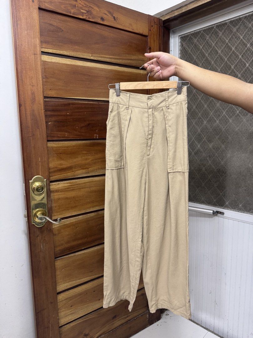 GU Beige Wide Leg Pants Size M (Category: Jeans) located in Cavite. Submitted by yakultjeni85475 (Listing ID 1469747089, Image 3). Description: - Brand/Model: GU - Color: Neutral beige (goes with everything) - Size: M - Material: Comfortable rayon and polyester blend - Design: Front pleats and side pockets with button closure - Style: Versatile wide leg pants, perfect for casual days or office wear.