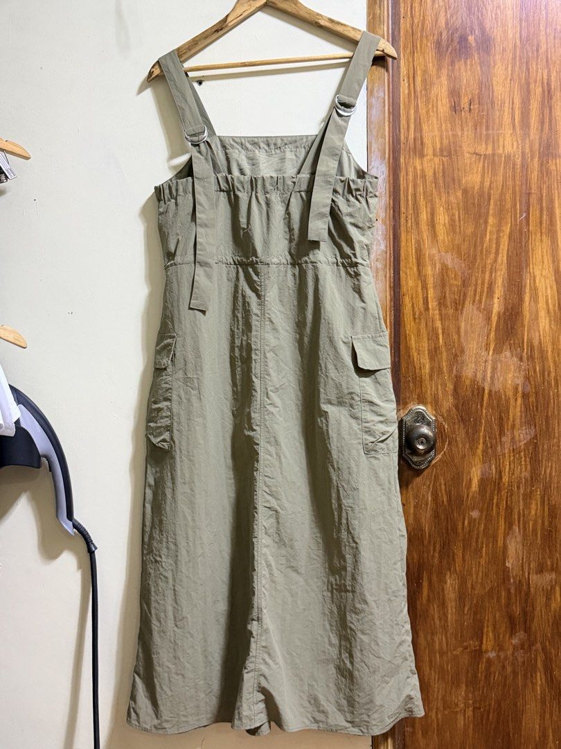 GU Olive Green Cargo Jumper Size L (Category: Jumpsuits) located in Paete. Submitted by skydruemadison (Listing ID 1469696500, Image 3). Description: - Brand: GU - Color: Olive Green - Size: Large - Style: Sleeveless utility jumper with square neckline and midi length - Material: Lightweight nylon - Features: Adjustable drawstring waist for a cinched fit and practical side cargo pockets on the skirt - Condition: Easy slip-on piece, perfect for ca