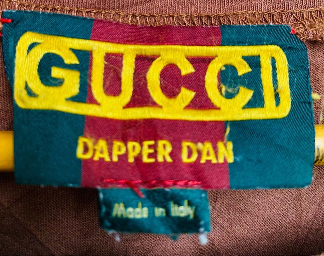 Gucci Dapper Dan Brown T-Shirt with Sequin Flowers (Category: Shirts) located in Digos. Submitted by thrifthed.ph (Listing ID 1469655003, Image 2). Description: - Authentic Gucci x Dapper Dan brown t-shirt -large -dimes:20.5/28 -like new -cl:10/10 -color may vary due to sun-light -need wash -authentic -solid condi -solid colorate -need wash - Bold yellow logo across the chest - Detailed red and green sequin flower embroidery along the neckline - 
