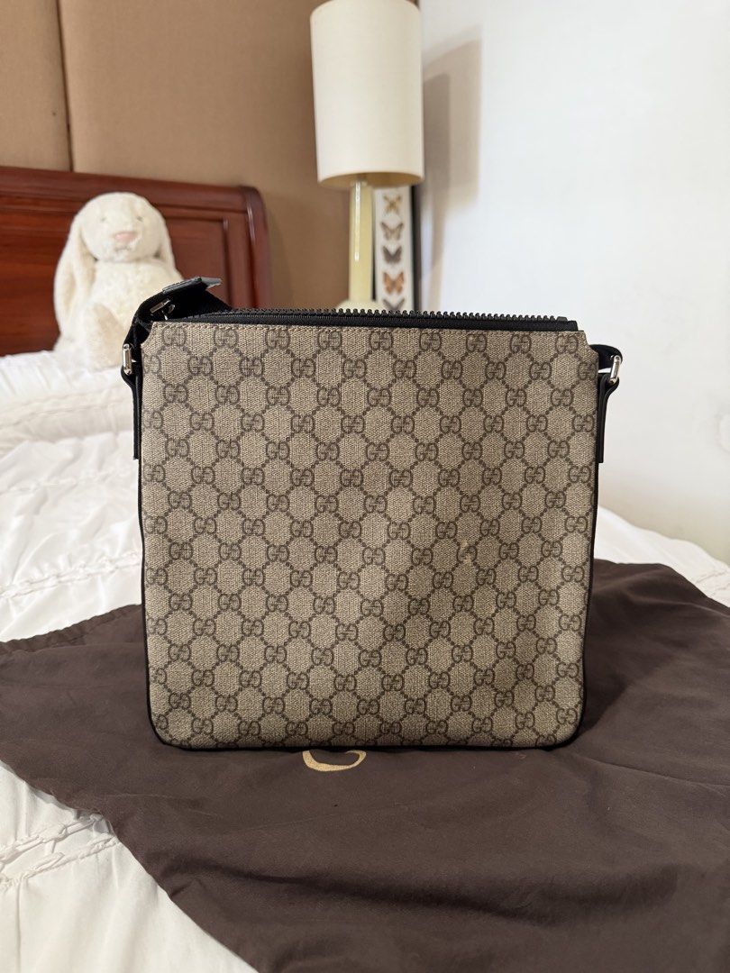 Gucci GG Supreme Messenger Flat Bag (Category: Sling Bags) located in Cavite. Submitted by gentlyused_ (Listing ID 1469682678, Image 2). Description: - Authentic Gucci messenger bag in classic GG Supreme canvas - Sleek black leather trim and adjustable strap for comfortable wear - Front zip pocket with polished silver-tone hardware - Secure top zip closure opening to a striking bright red interior lining - Ideal everyday crossbody size and shape 
