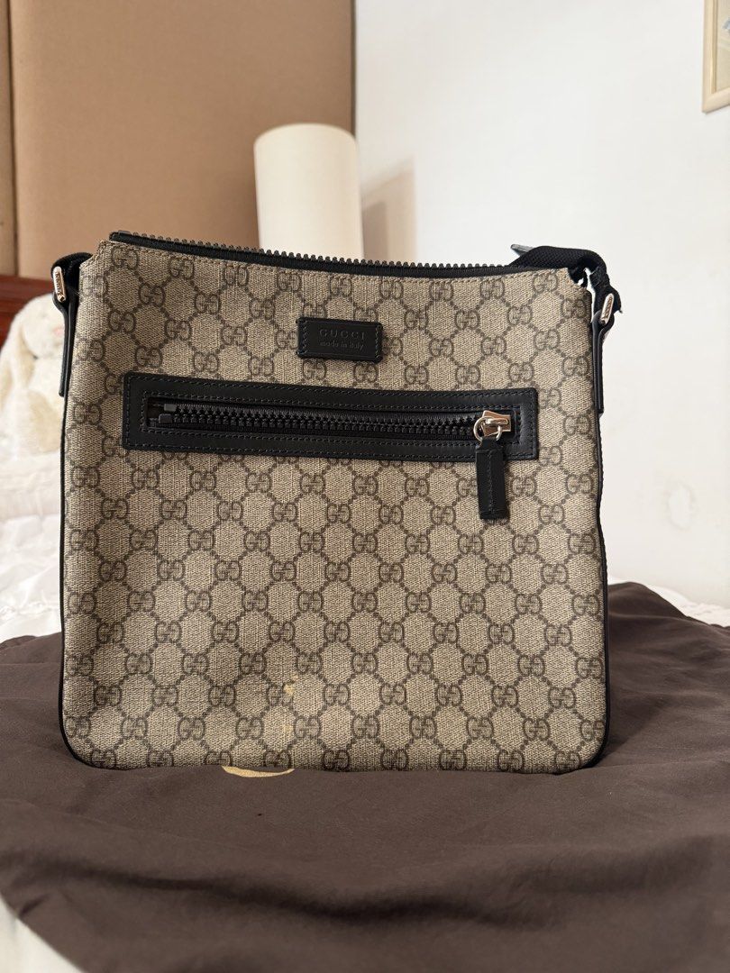 Gucci GG Supreme Messenger Flat Bag (Category: Sling Bags) located in Cavite. Submitted by gentlyused_ (Listing ID 1469682678, Image 1). Description: - Authentic Gucci messenger bag in classic GG Supreme canvas - Sleek black leather trim and adjustable strap for comfortable wear - Front zip pocket with polished silver-tone hardware - Secure top zip closure opening to a striking bright red interior lining - Ideal everyday crossbody size and shape 