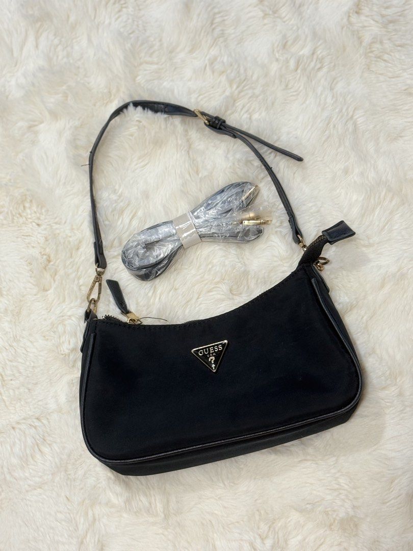 Guess Black Shoulder Bag with Extra Strap (Category: Shoulder Bags) located in Manila. Submitted by preshyyyyy_ (Listing ID 1469746739, Image 1). Description: Guess black nylon shoulder bag with gold-tone hardware and iconic triangle logo plaque on the front. Zip top closure. Includes an extra unopened detachable strap wrapped in plastic, ready to swap. Clean fabric body and structured piping. Great size for daily essentials, phone, and keys. Gra