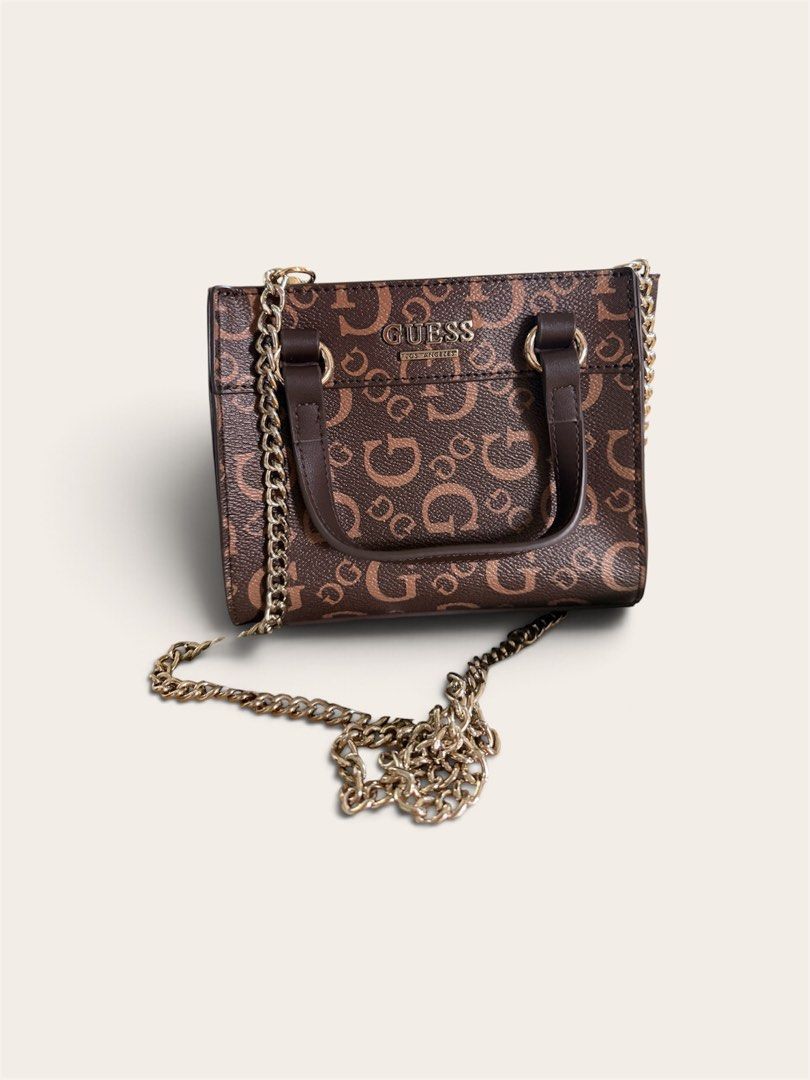 Guess Brown Monogram Tote Crossbody Bag (Category: Cross-body Bags) located in Pasig City. Submitted by annabanana09 (Listing ID 1469584212, Image 1). Description: - Brand: Guess - Design: Brown monogram with all-over G print and dark brown top handles - Hardware: Elegant gold-tone branding on the front - Versatility: Includes a detachable gold chain strap for crossbody wear - Size & Shape: Compact and structured - Condition: Clean inside and out