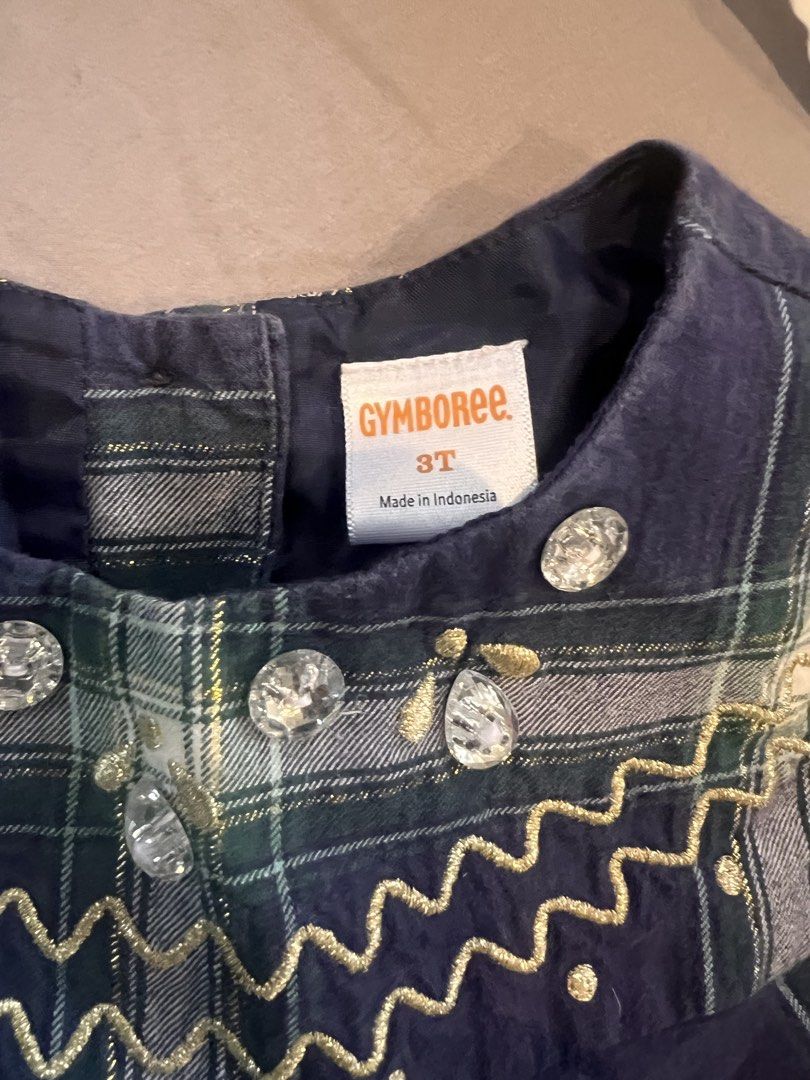 Gymboree Plaid Dress Size 3T (Category: Babies & Kids Fashion) located in Manila. Submitted by asecondstory (Listing ID 1469584372, Image 2). Description: - Brand: Gymboree - Size: 3T - Pattern: Classic tartan plaid in navy blue, green, and white - Material: Soft and comfortable cotton - Design: Short sleeves, rounded neckline, and back button closure - Details: Sparkling rhinestone accents and elegant gold metallic embroidery on the chest yoke.