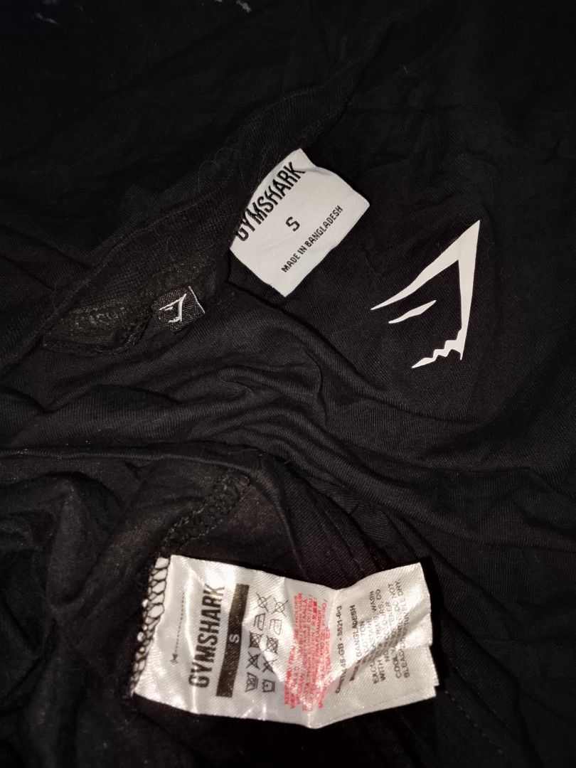 Gymshark Black T-Shirt Size S (Category: Tshirts & Polo Shirts ) located in Las Pinas. Submitted by solisjethr46316 (Listing ID 1469710473, Image 2). Description: - Brand: Gymshark - Color: Black with white sharkhead logo - Size: Small - Material: Cotton and elastane blend (Made in Bangladesh) - Features: Short sleeves, crew neckline, clear interior branding tags - Condition: Clean and well-maintained.