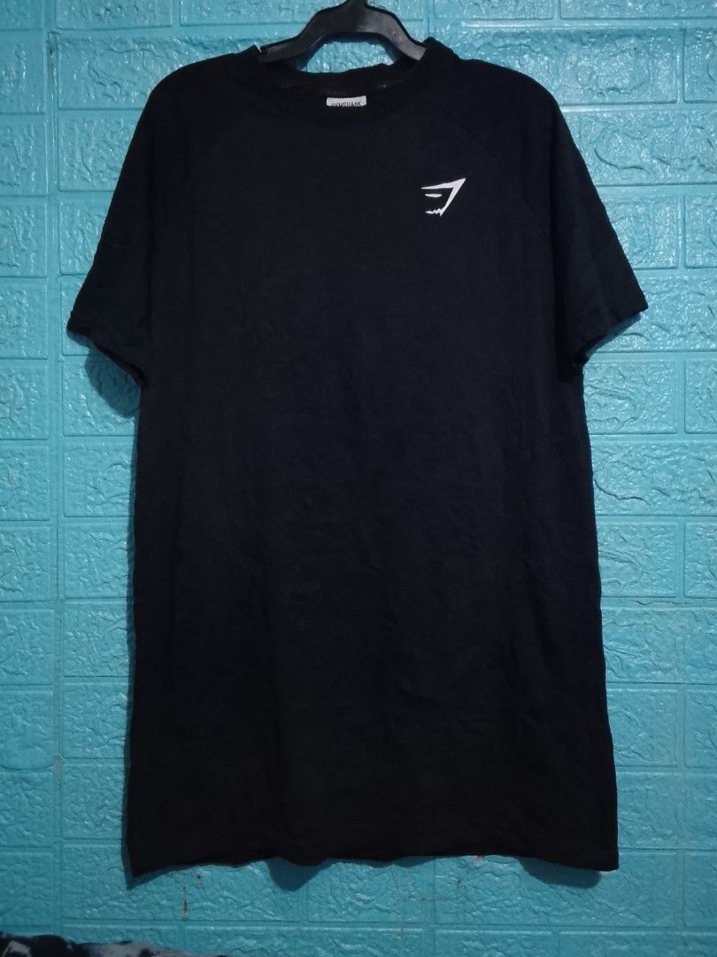 Gymshark Black T-Shirt Size S (Category: Tshirts & Polo Shirts ) located in Las Pinas. Submitted by solisjethr46316 (Listing ID 1469710473, Image 1). Description: - Brand: Gymshark - Color: Black with white sharkhead logo - Size: Small - Material: Cotton and elastane blend (Made in Bangladesh) - Features: Short sleeves, crew neckline, clear interior branding tags - Condition: Clean and well-maintained.