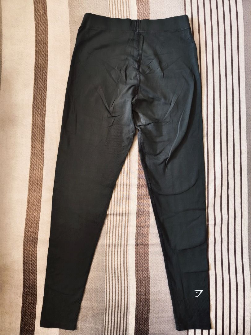 Gymshark Leggings Medium (Category: Activewear) located in Pasig City. Submitted by peachesncreams (Listing ID 1469709694, Image 2). Description: - Brand: Gymshark - Color: Greyish Colorway - Details: Signature logo near waistband and lower leg - Features: Supportive ribbed waistband and high-stretch fabric - Ideal for: Workouts, running, and everyday athleisure - Condition: Well-maintained with plenty of wear left -Medium size - Width 28-32" -Le