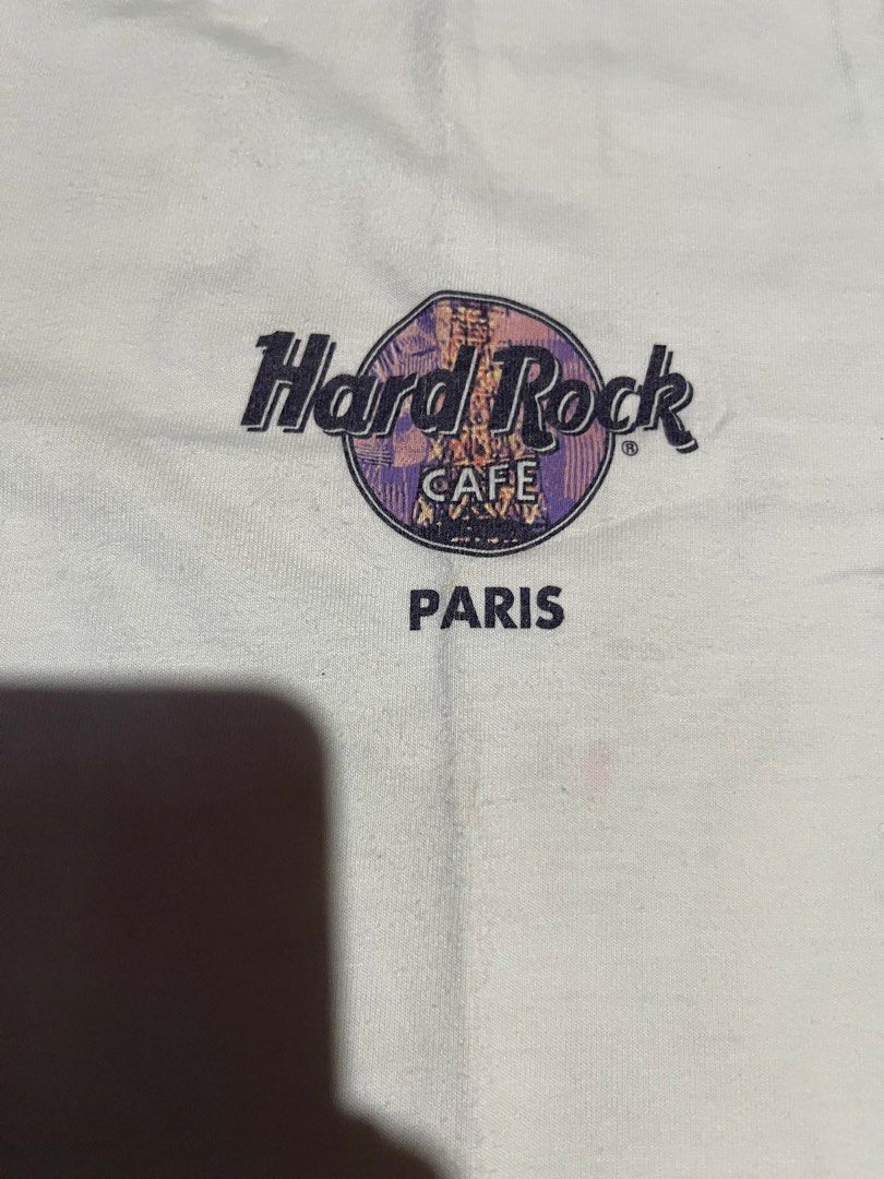 HARD TAG Hard Rock Cafe Paris Heavy Tee White Small (Category: Tshirts & Polo Shirts ) located in Cavite. Submitted by christianzuuu (Listing ID 1469603280, Image 3). Description: - Authentic Hard Rock Cafe Paris T-Shirt - Color: White - Size: Small (fits true to size) - Measurements: 17.5" pit to pit, 28.5" length - Material: Premium heavyweight cotton - Design details: Front chest logo, large Eiffel Tower back graphic, and 'HRC Built on Rock n 