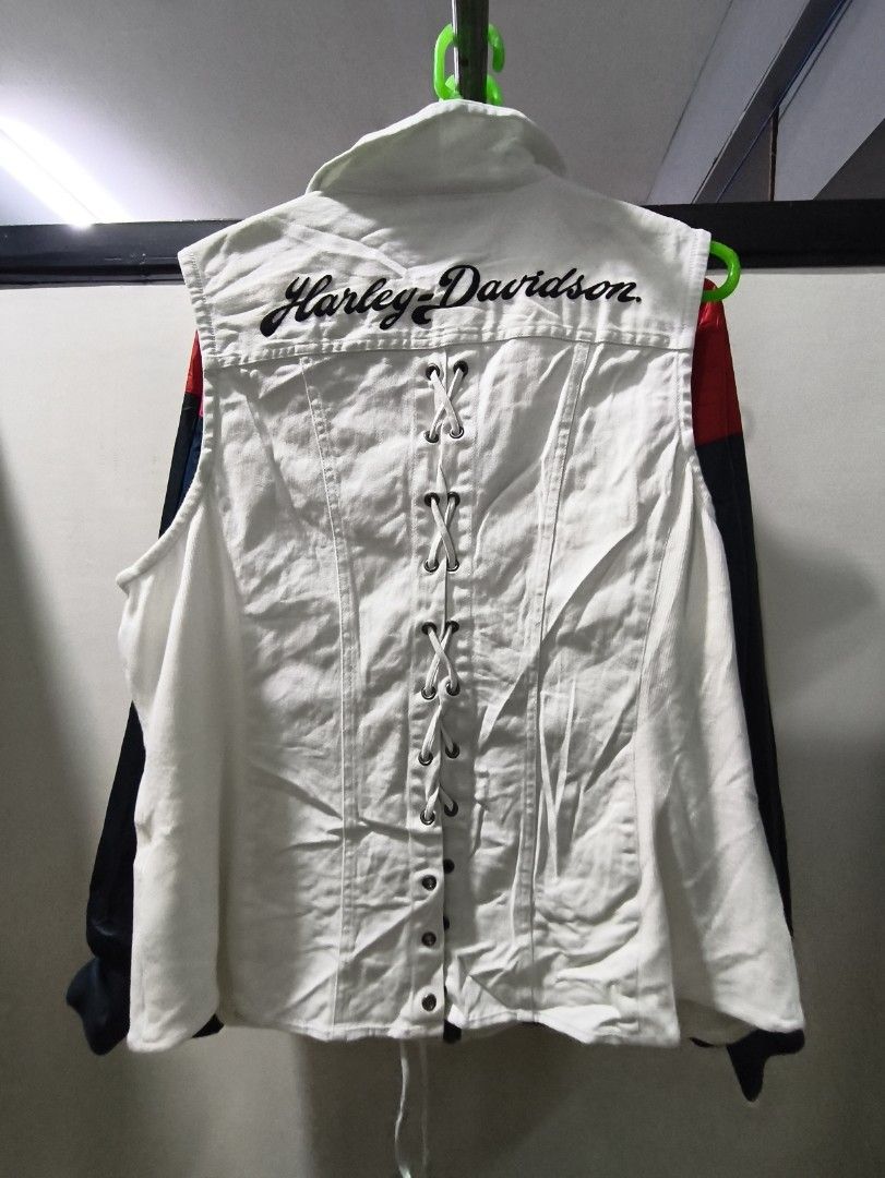 Harley-Davidson White Biker Vest (Category: Vests) located in Manila. Submitted by p4ul.thrift (Listing ID 1469576932, Image 2). Description: - Brand: Harley-Davidson - Color: Clean white with black lettering and hardware - Material: Comfortable cotton and spandex blend (inner tag included) - Closure: Front zipper with small chest zip pocket - Details: H-D logo embroidery near bottom hem - Back Design: Trendy lace-up corset detail with large Harl