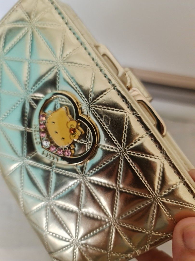 Hello Kitty Gold Quilted Wallet Purse (Category: Wallets & Card holders) located in Marilao. Submitted by joycehart (Listing ID 1469611904, Image 1). Description: - Elegant gold quilted design featuring a sparkly Kitty heart charm and back bow detail - Secure snap button closure and kiss-lock zippered coin compartment - Organized interior with multiple card slots and a clear ID window - Beautiful cream-colored lining complete with an official Kit
