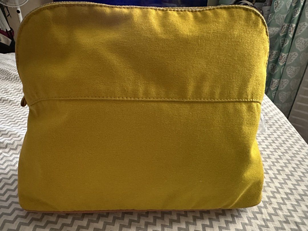 Hermès Yellow Canvas Pouch (Category: Purses & Pouches) located in Antipolo. Submitted by prelovedcloseta (Listing ID 1469609607, Image 2). Description: - Color: Bright yellow canvas with brown leather base trim - Design: Embroidered H logo inside an oval on the front - Closure: Zipper closure with a convenient leather pull tab - Interior: Clean fabric inside and out, structured shape to keep items organized - Condition: Excellent, well-maintaine