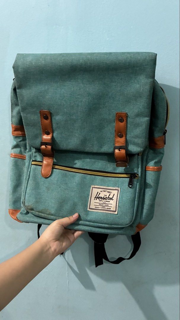 Herschel Supply Co. Teal Canvas Backpack (Category: Backpacks) located in Manila. Submitted by dukejah (Listing ID 1469579997, Image 1). Description: - Color: Teal canvas with brown faux leather trim - Storage: Main zip compartment with internal laptop sleeve and securing strap - Pockets: Front zip pocket for small items and magnetic snap flap closure - Comfort: Padded, fully adjustable mesh shoulder straps - Condition: Clean interior lining, wit