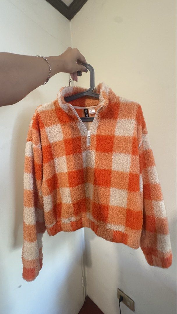 H&M Divided Orange Checkered Sherpa Fleece Jacket (Category: Coats, Jackets and Outerwear) located in Makati City. Submitted by marykay05 (Listing ID 1469619646, Image 2). Description: - Brand: H&M Divided - Size: XS - Design: Orange and white checkered pattern - Style: Quarter zip, high neck, cropped length, relaxed fit - Material: Super soft fuzzy fleece - Perfect for: Cold weather streetwear.