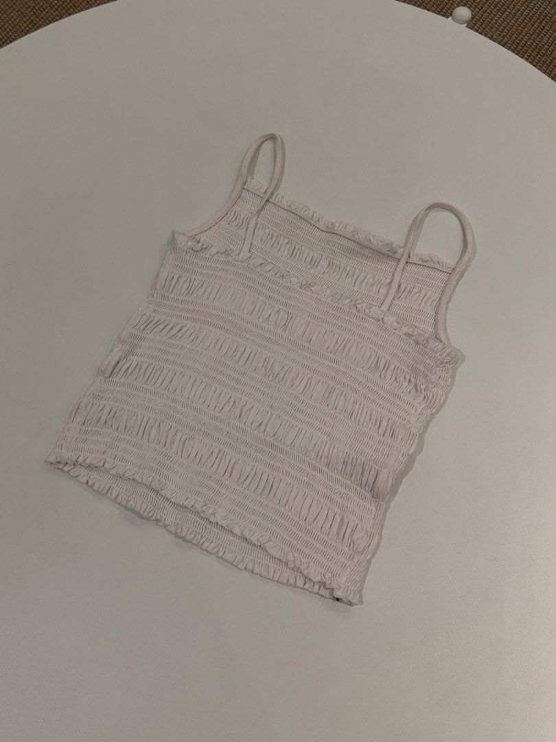 H&M White Smocked Cami Crop Top (Category: Sleeveless) located in Muntinlupa City. Submitted by henlo03 (Listing ID 1469611710, Image 3). Description: - Brand: H&M - Size: M - Color: White - Fit: Fully smocked and stretchy body - Details: Thin shoulder straps and ruffled hems - Style: Versatile basic piece, easy to match with jeans or skirts.