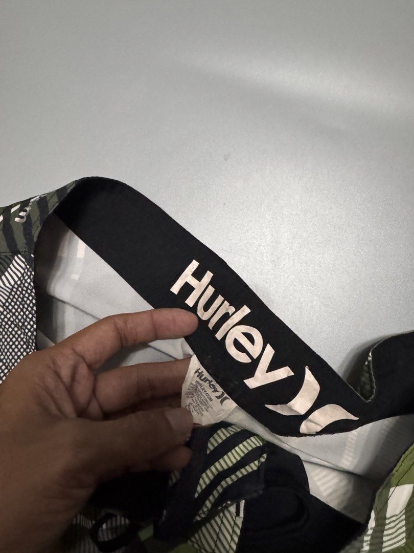 Hurley Phantom Green Plaid Board Shorts (Category: Swim Trunks & Board Shorts) located in Alaminos. Submitted by outfitcheck.ph (Listing ID 1469698866, Image 2). Description: - Brand: Hurley Phantom - Design: Green, black, and white plaid - Waistband: Drawstring with Hurley logo lettering - Pockets: Convenient small zip pocket on the right leg - Branding: Iconic Hurley logos on the left leg and back waist - Condition: Excellent / Great for surf, 