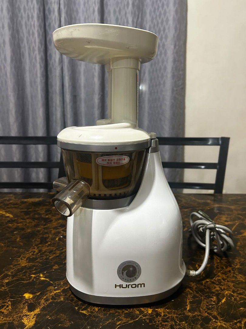 Hurom Slow Juicer (Category: Juicers, Blenders & Grinders) located in Taguig. Submitted by lhadychinitah (Listing ID 1469682110, Image 1). Description: - Brand: Hurom Slow Juicer - Color: White with clear/yellow strainer components - Condition: Good pre-loved condition, complete parts included (motor base, juicing bowl, auger, strainer, hopper, pusher) - Features: Slow squeezing technology for maximum nutrient retention, easy-to-use ON/REV switch
